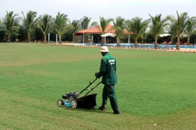 groundskeeper mowing the lawn at Diambars facilities in Saly, Senegal