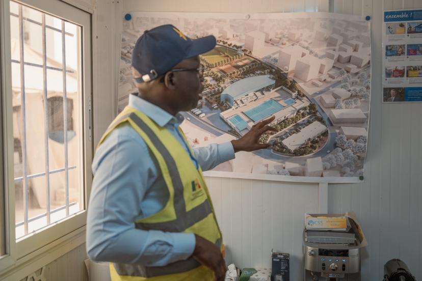Babacar Senghor, coordinator of the Dakar 2026 Youth Olympic Games project, reviewing plans for the Olympic swimming pool