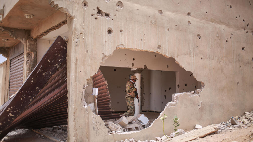 A soldier from the National Liberation Front of Azawad (FLA) walks through a damaged building in Kidal, May 9, 2026.