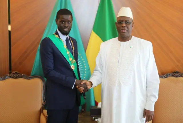 Newly elected Senegalese president Bassirou Diomaye Faye (left) shakes hands with former president Macky Sall (right) during a photo session after swearing in before the Constitutional Council, at the inauguration ceremony in Dakar, Senegal, 2 April 2024