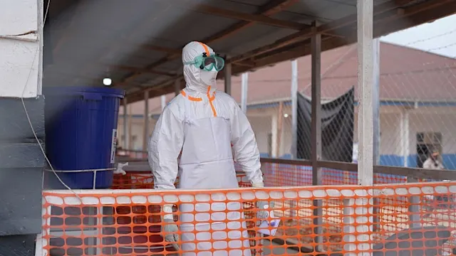 Health workers in protective gear attending to patients