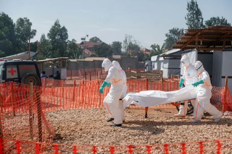 Health workers in protective gear transporting an Ebola patient in Democratic Republic of Congo